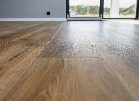 Modern vinyl panels imitating wood in the living room with selective focus and a shadow falling from the window.